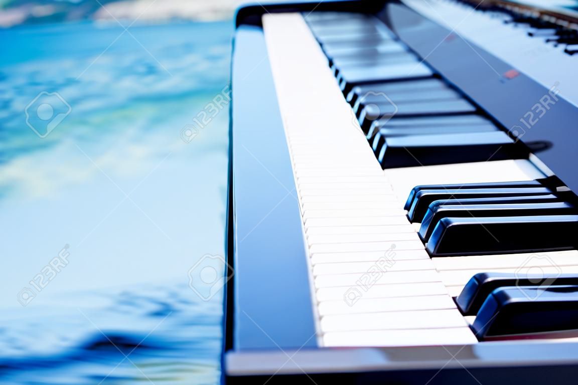 バックグラウンドでピアノのキーボードと海や海
