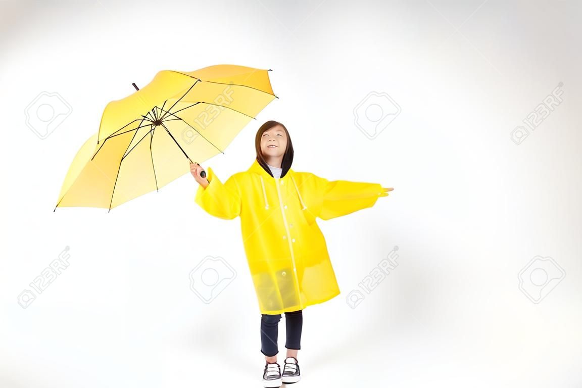 Asian female child in raincoat with umbrella isolated on white