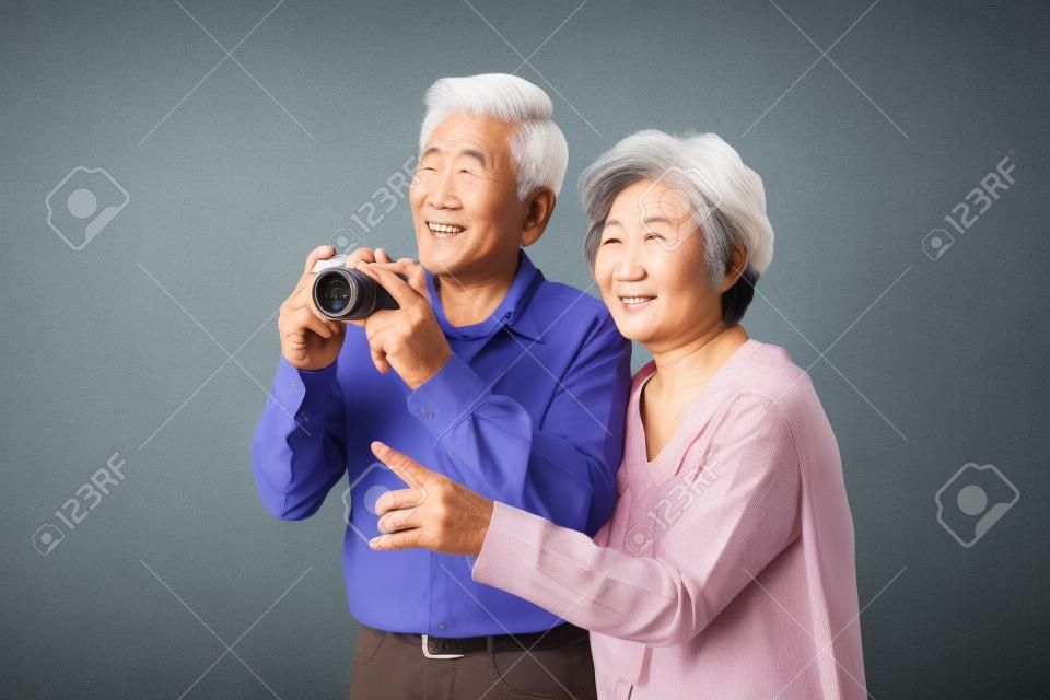 Asian old aged couple taking a picture isolated on white
