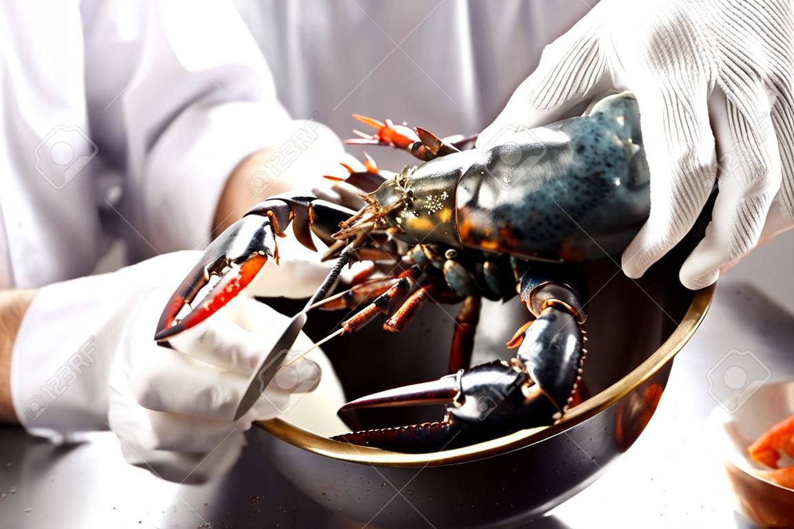 hand putting tied up lobster in large brass bowl