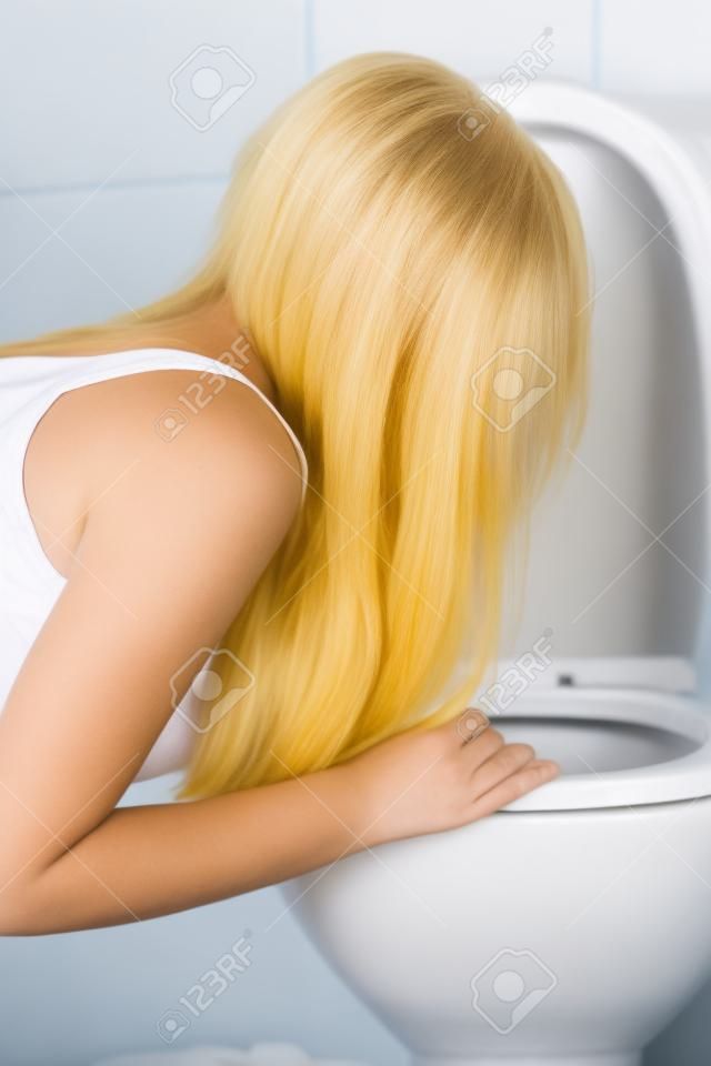 Jovem loira adolescente mulher vomitando no banheiro