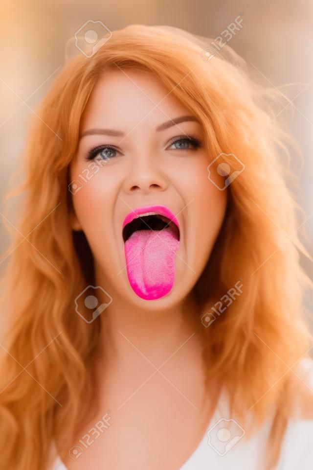 Portret van mooie vrouw die tong uitsteekt