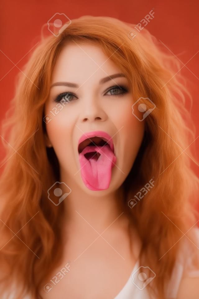Retrato de mujer hermosa que pone la lengua fuera
