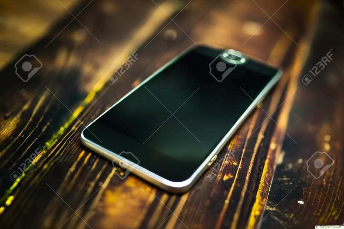 Czarny telefon komórkowy na drewnianym stole