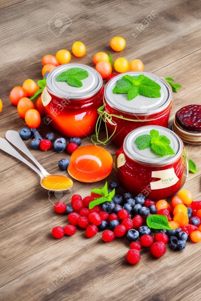 assortment of jams, seasonal berries, apricot, mint and fruits. marmalade or confiture