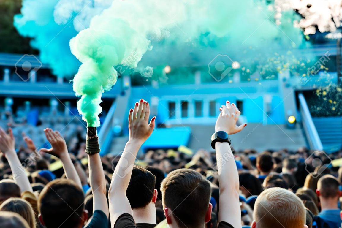Folla a un concerto di musica, pubblico che alza le mani