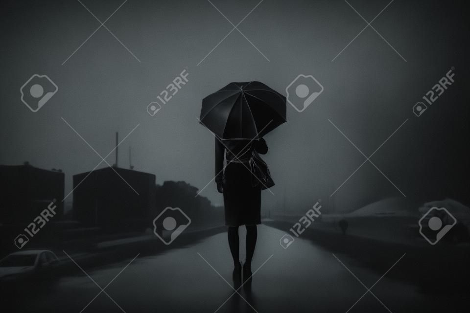 Woman are holding an umbrella, dark image