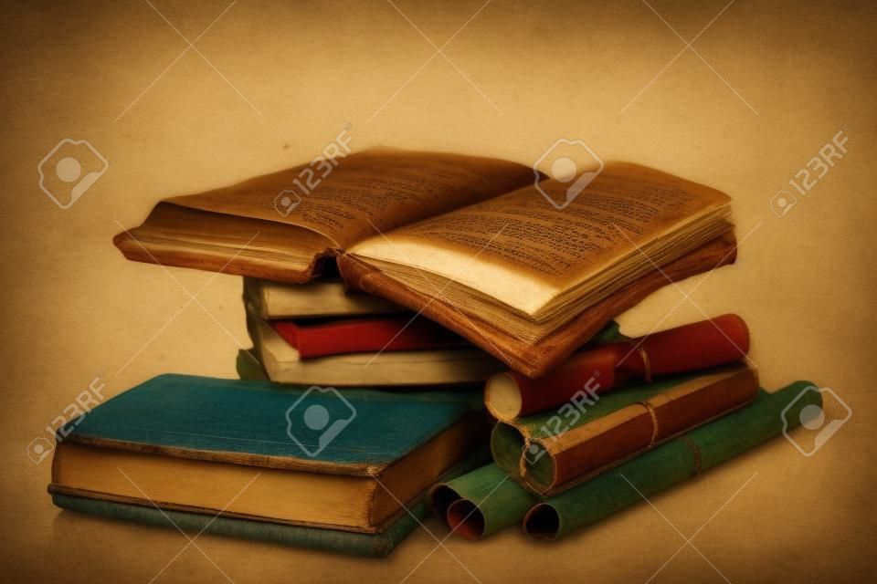 Pila de libros antiguos y desplácese aislado en blanco