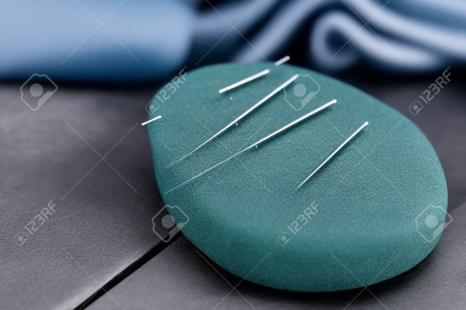 Agulha para acupuntura em pedras de spa na mesa close up