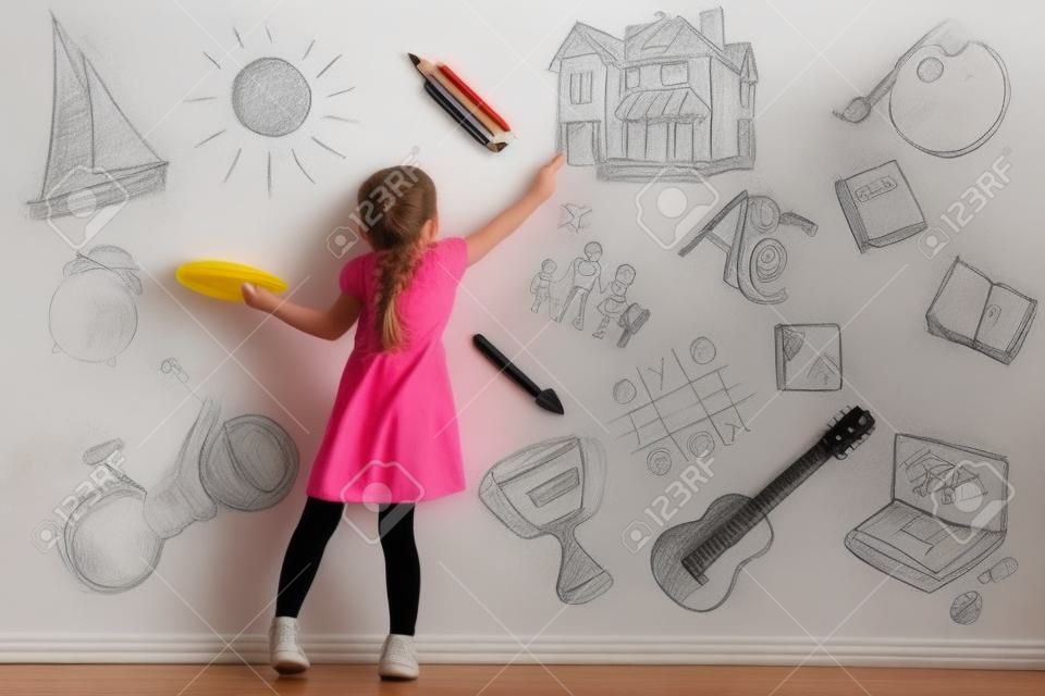 Cute little girl drawing on light wall. Different sketches on background�