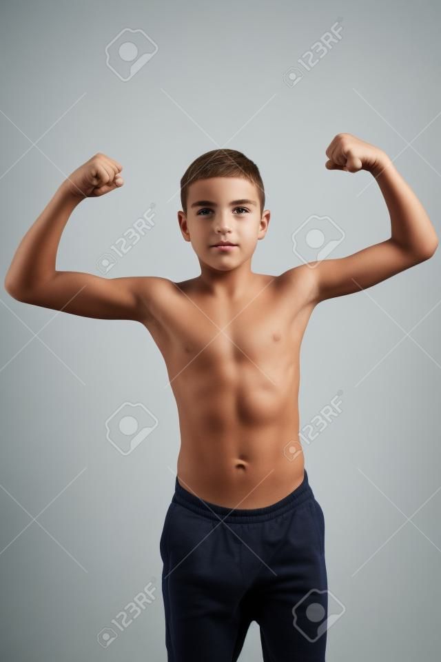 Shirtless teenage boy flexing his muscles isolated on white background