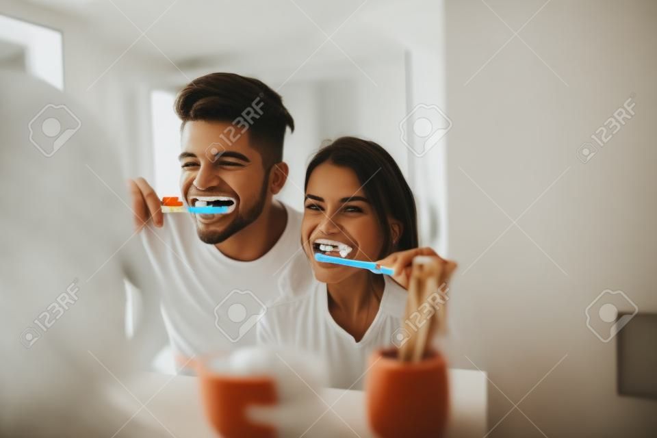 Foto de la joven pareja se divierte mientras se cepilla los dientes en el baño.