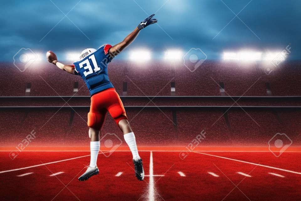 Football Player with a red uniform catching a ball on a stadium.