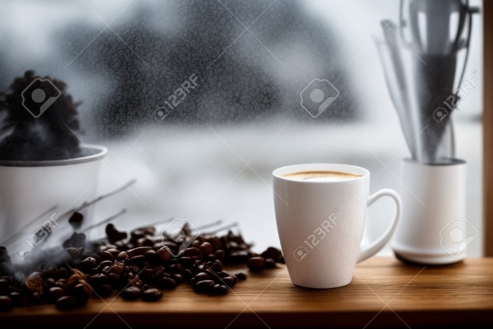 Parującą filiżankę kawy w deszczowy dzień tle okna