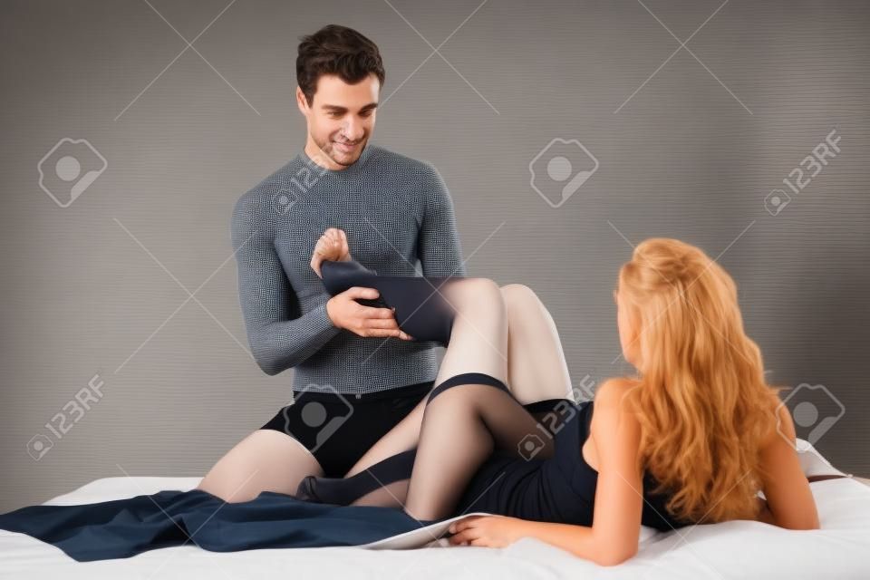 Man taking off tights from woman's legs