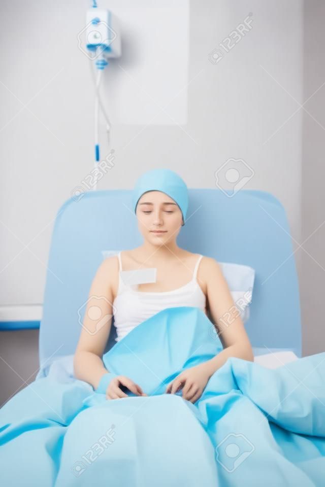 Mujer bonita joven enferma sentado en la cama de hospital