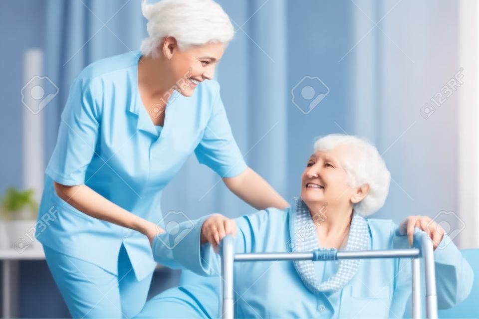 Senior Frau mit Gehhilfe und Unterstützung Krankenschwester