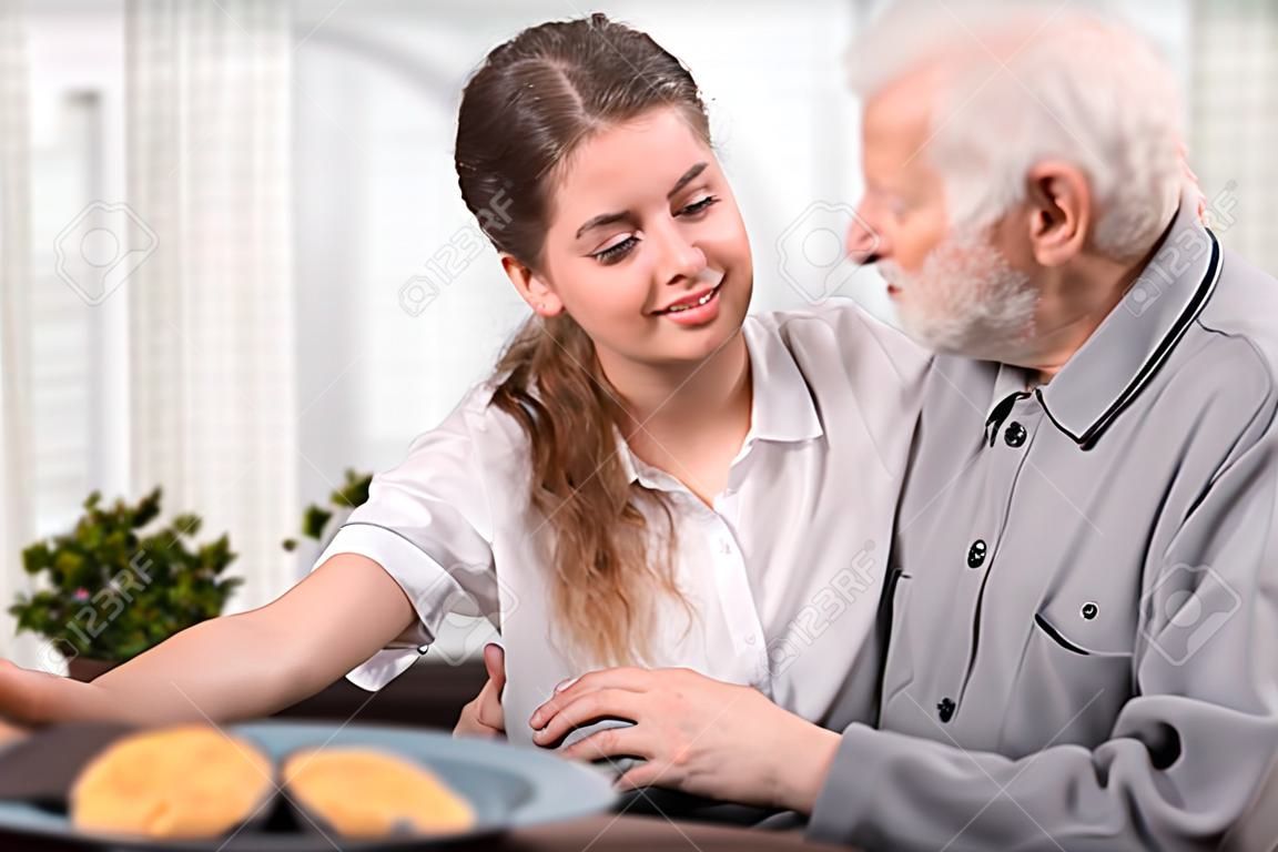 Giovane volontario visita uomo anziano bisognoso
