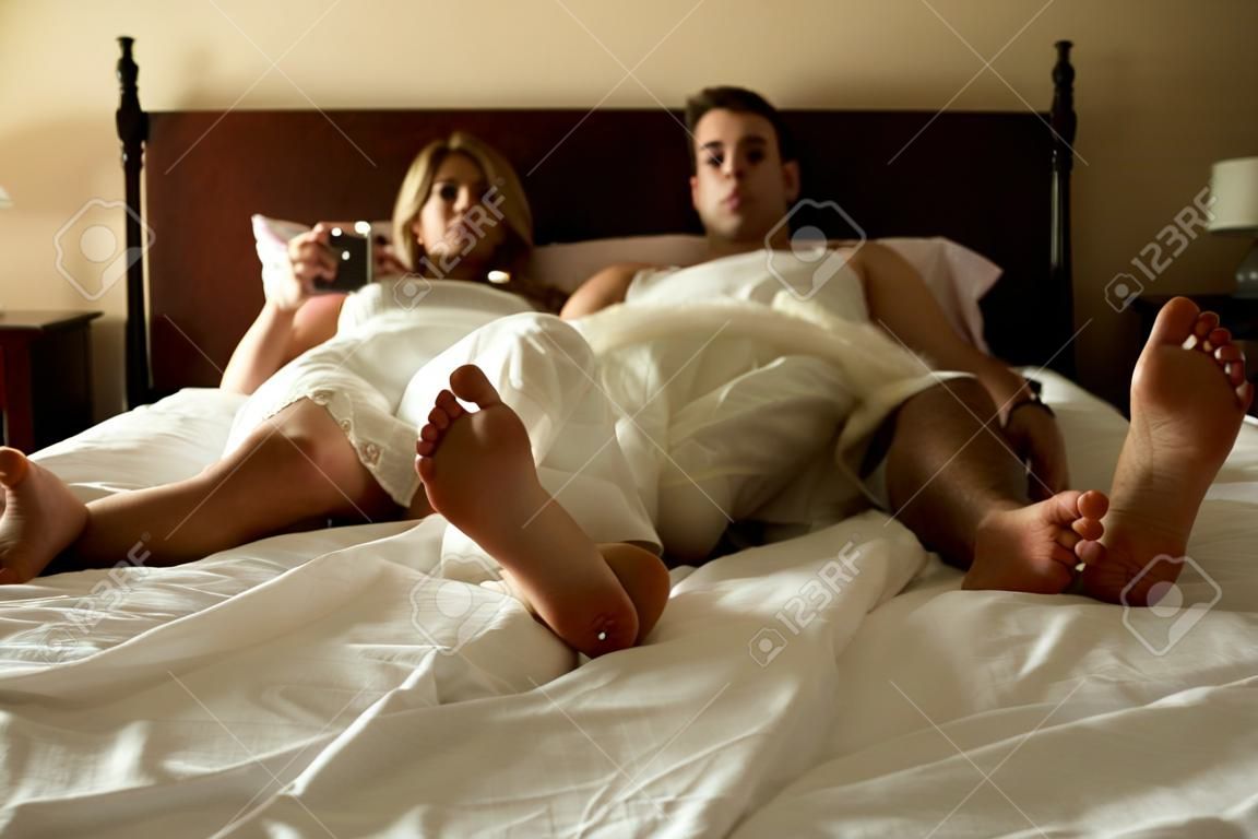 Молодая пара, лежа в постели