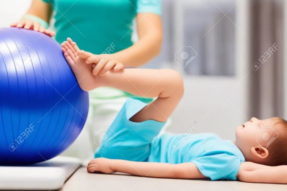 Foto van kleine patiënt die oefeningen doet met fitnessbal