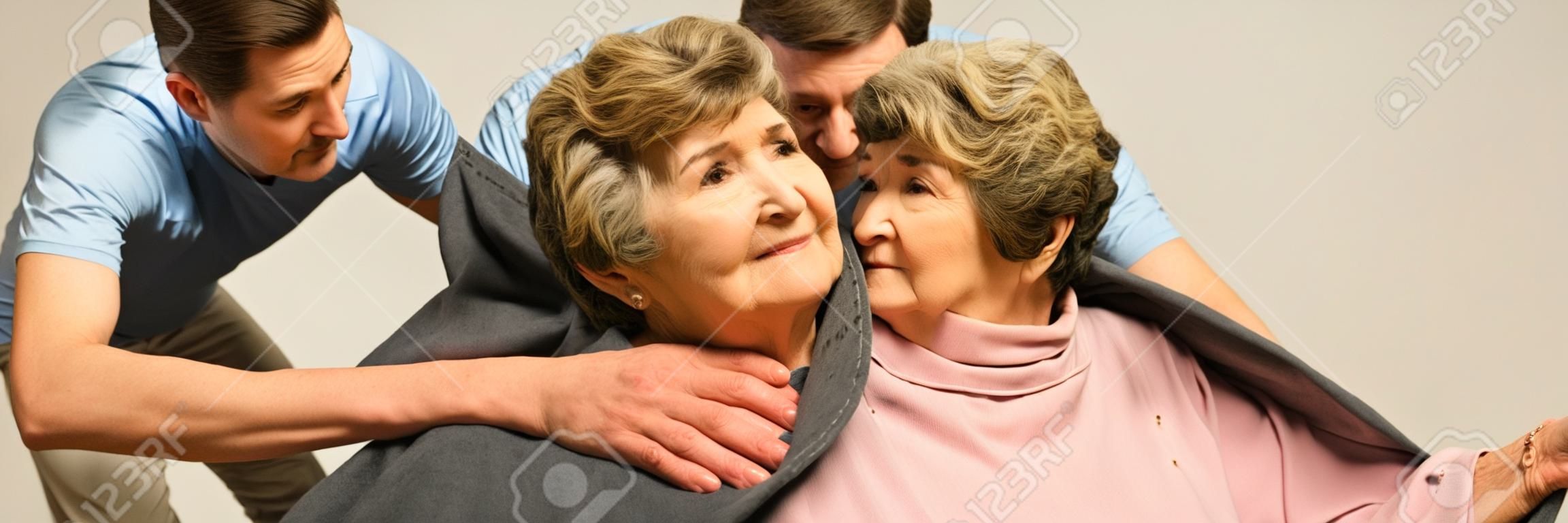 Male helpful caregiver taking care of senior woman
