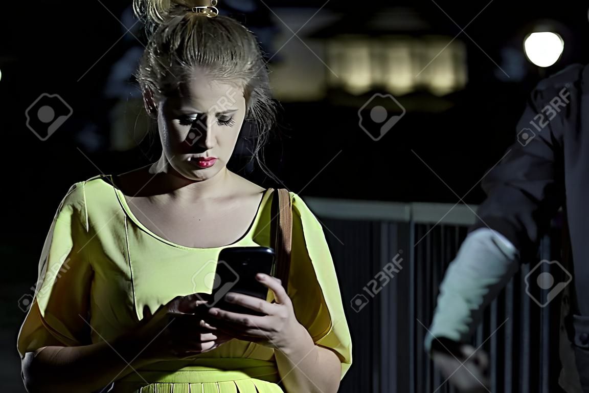 Woman with mobile phone walking alone at night