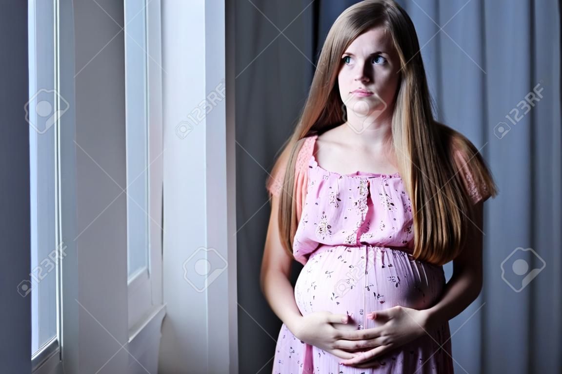 Terhes tizenéves lány aggodalmasan