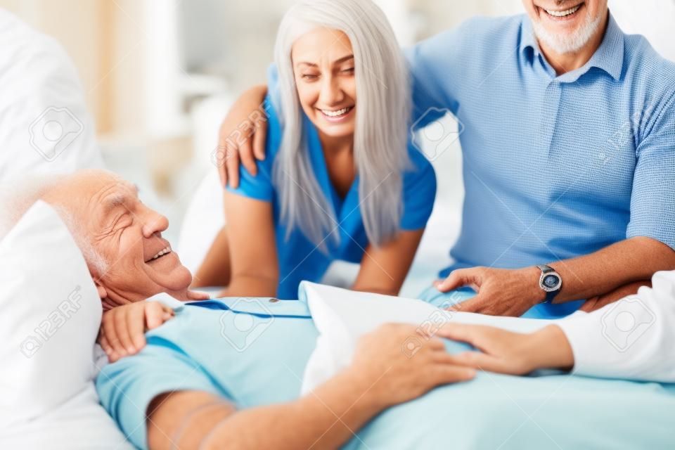 Osoby w podeszłym wieku człowiek leżący w szpitalnym łóżku w otoczeniu swoich wnuków i żony