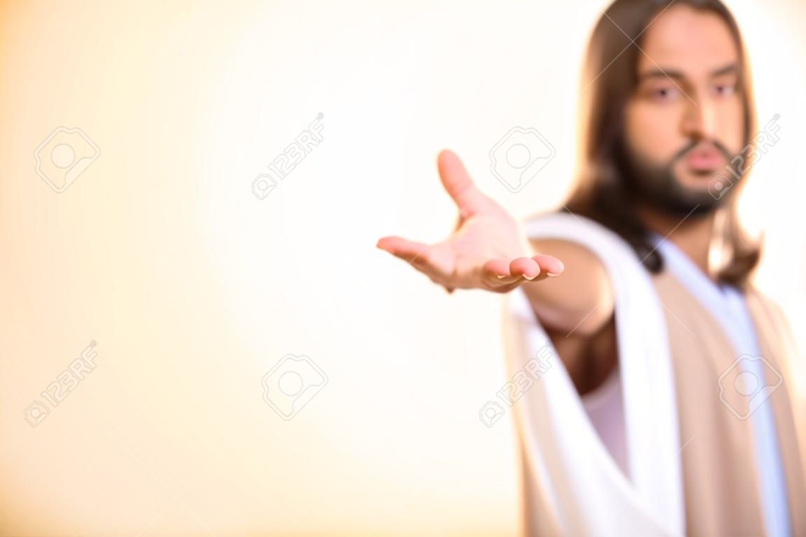 Mesih aydınlatılmış arka plan üzerinde izole elini uzanarak