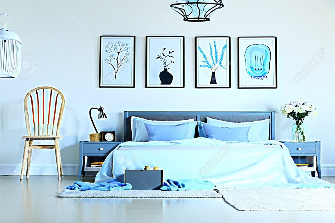 드레싱 테이블, 의자, 침대, 포스터 및 램프가있는 밝은 침실