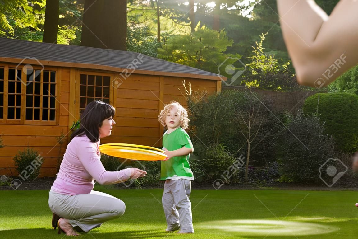 Familie spelen met een frisbee in de tuin