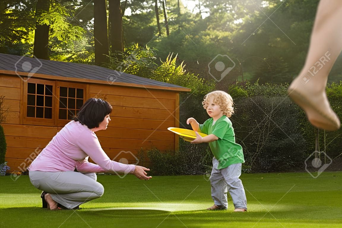 Familie spelen met een frisbee in de tuin