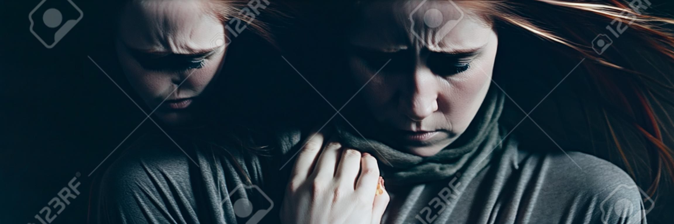 Jovem mulher solitária com depressão sendo frio no escuro