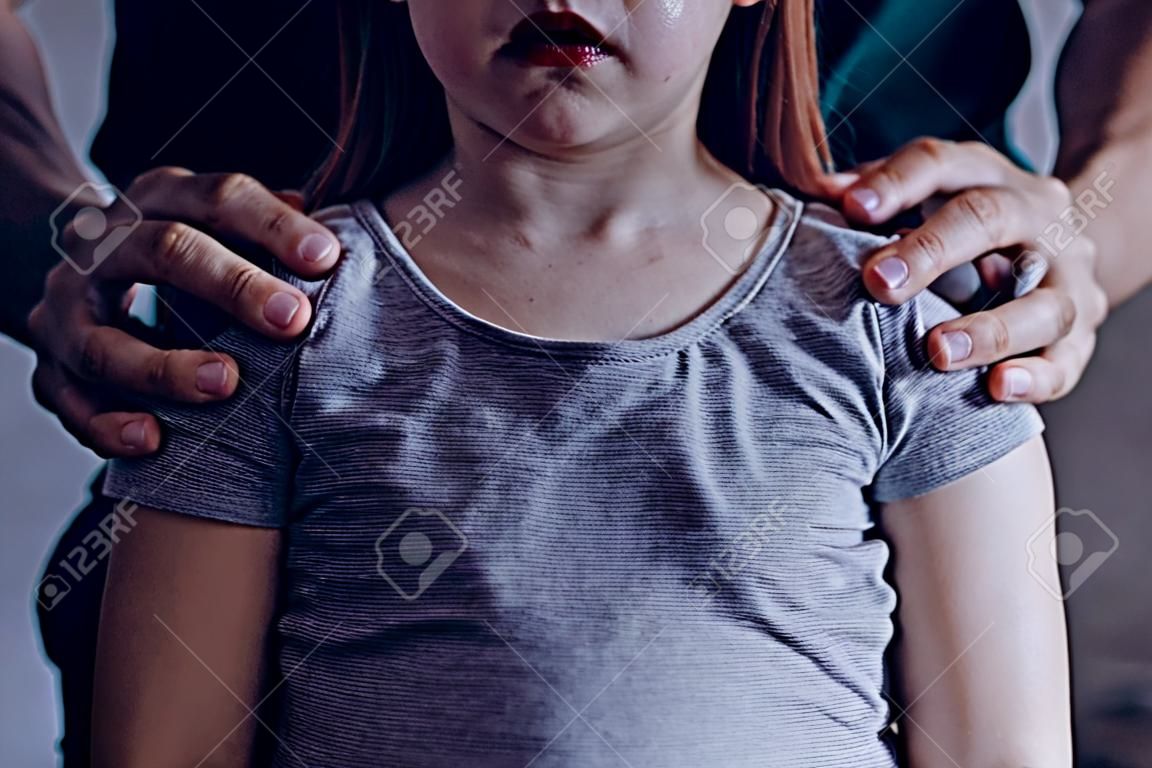 Mãos masculinas na menina chorando, conceito de exploração de crianças