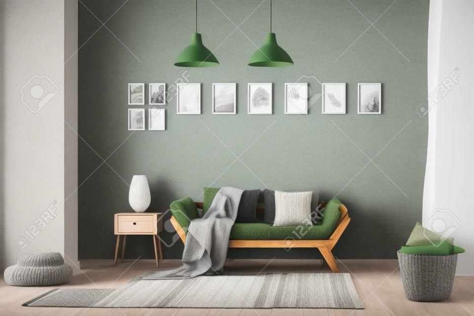 Gestrickte Decke auf Holzsofa, bequemem Puff und Korb mit weichen Kissen im gemütlichen Wohnzimmer mit natürlichen grünen Akzenten