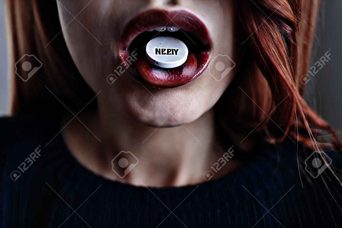 Close-up van de mond van het meisje met een pil op tong.