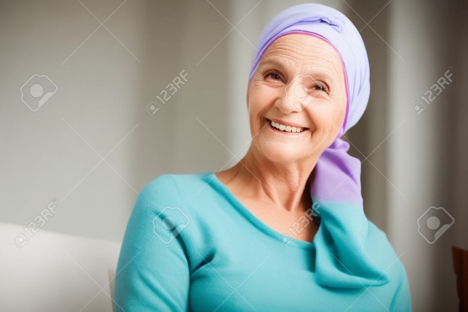 Boldog, idős nő portréja egy fejkendőben a rákos betegek számára, felépülve a betegségből