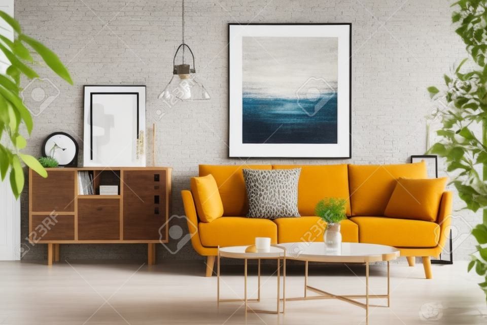 Foto real de um armário de madeira ao lado de um sofá em um interior moderno da sala de estar com uma pintura grande