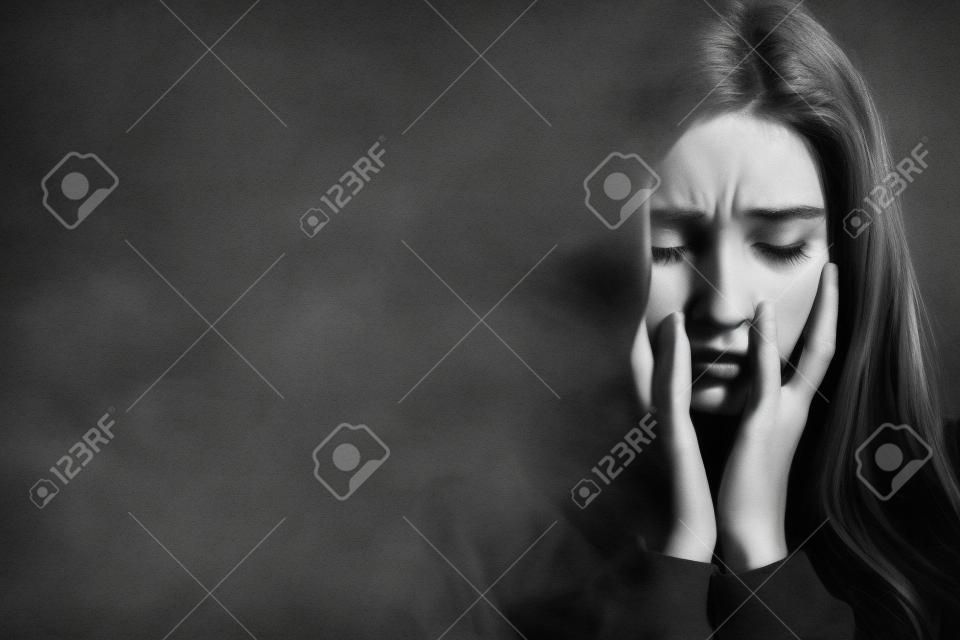 Zwart-wit beeld van bange mooie jonge roodharige vrouw met posttraumatische stress stoornis met slaapproblemen