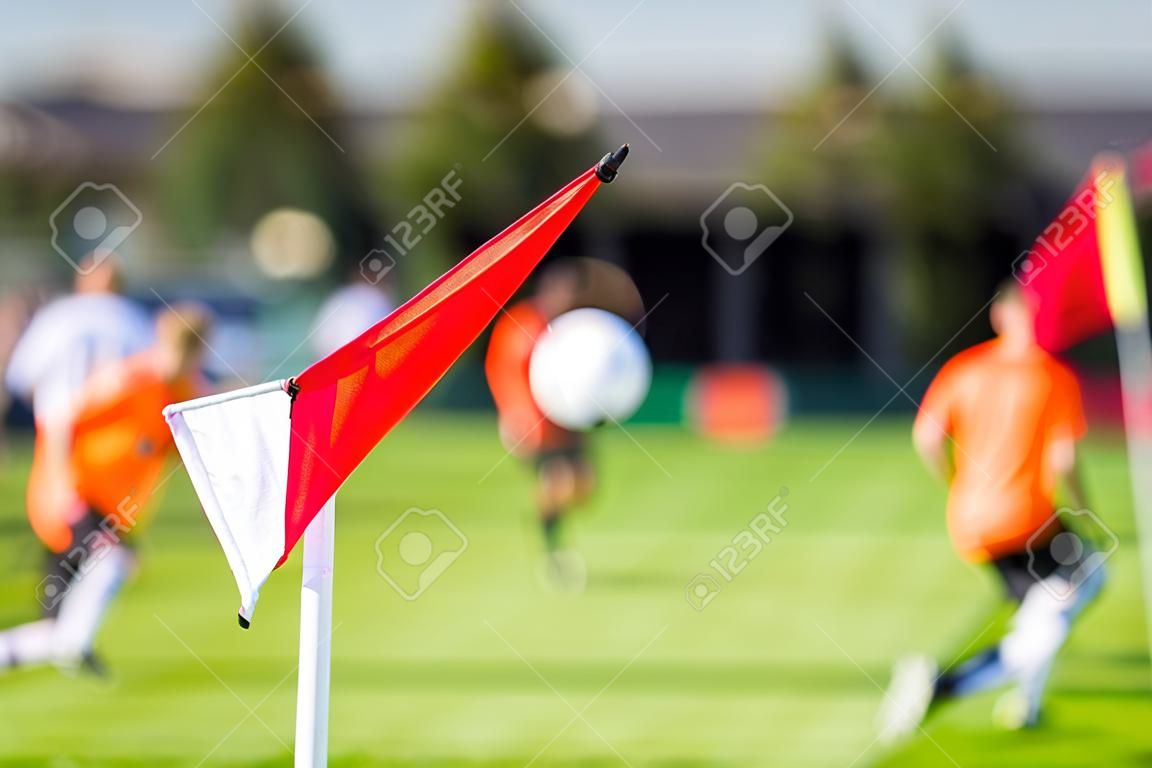 Shallow depth of field shot of group of male soccer players playing amateur soccer match on sunny summer day on simple sports venue in Denmark.