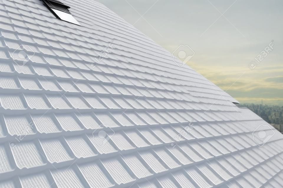Snow guard for safety in winter on house roof top covered with steel shingles. Tiled covering of building