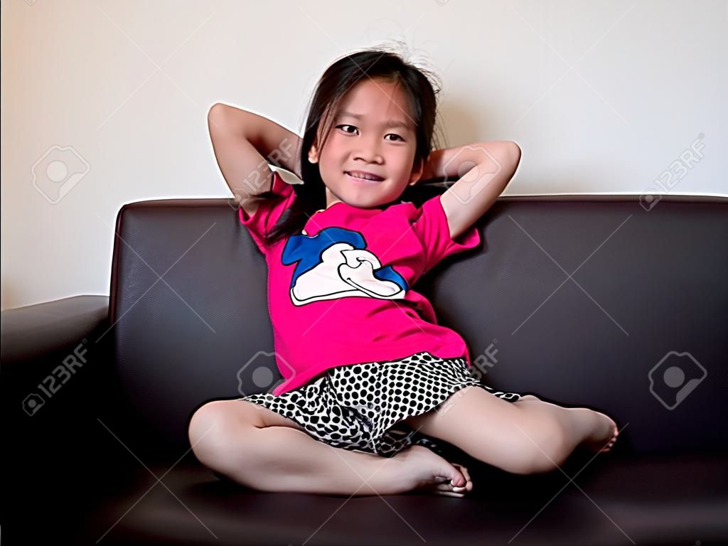 little asian child girl kid stretch oneself  on the sofa after her daytime sleepiness