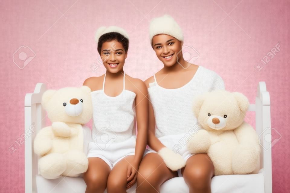 Big Babys. Zwei Säugling Jugendlichen in Babybekleidung und Windeln halten Teddybären und lächelnd