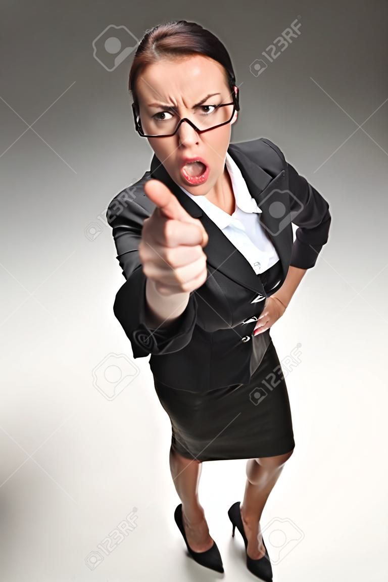 Wütend lustig Geschäftsfrau isoliert auf grauem Hintergrund. wütende Frau suchen und nach oben in die Kamera