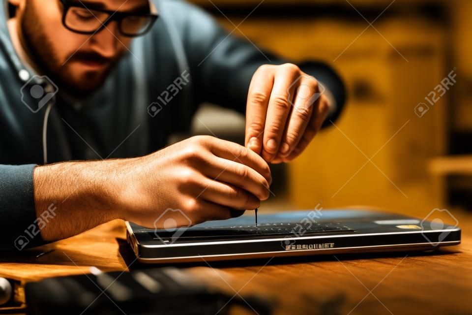 エンジニアは、ドライバーでノートパソコンを修理します。クローズ アップ。