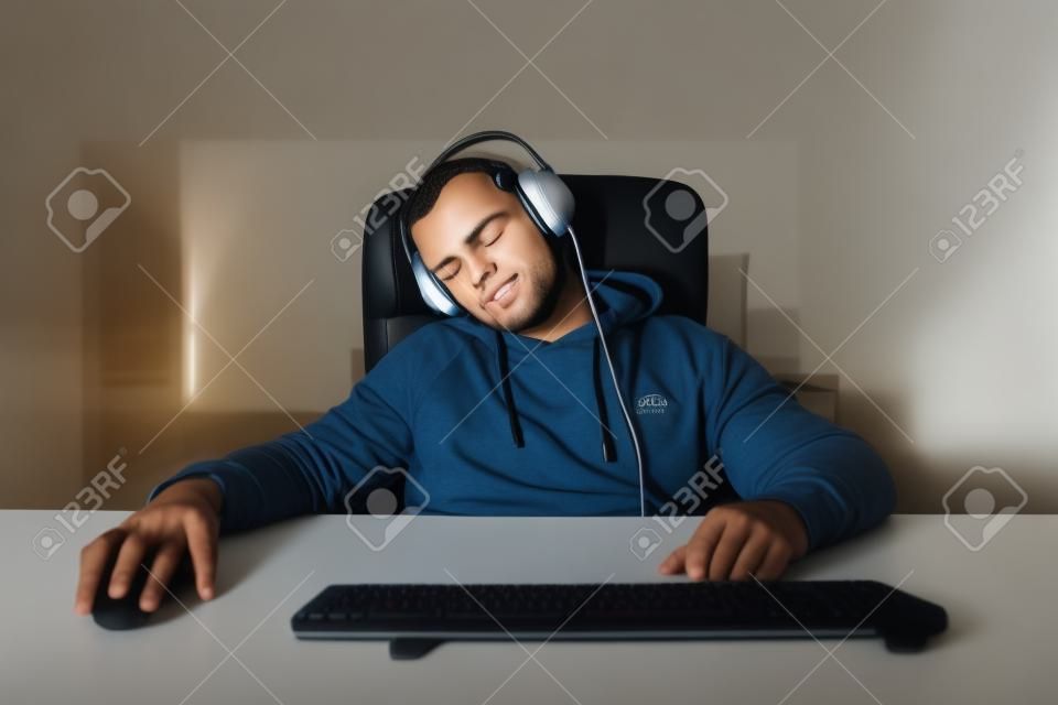 Gamer dormido en casa en la computadora. Joven durmiendo en casa jugando.