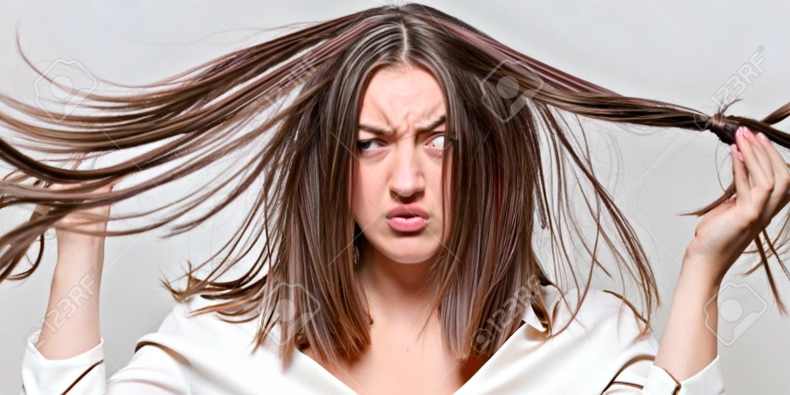Girl having a bad hair. Bad hairs day. Frustrated woman having a bad hair. Woman having a bad hair, her hair is messy and tangled