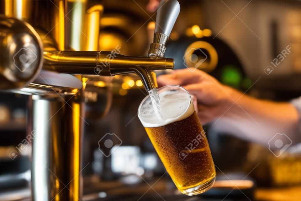 レストランやパブで提供ドラフト ラガー ビールを注ぐビールでバーテンダーの手をタップします。