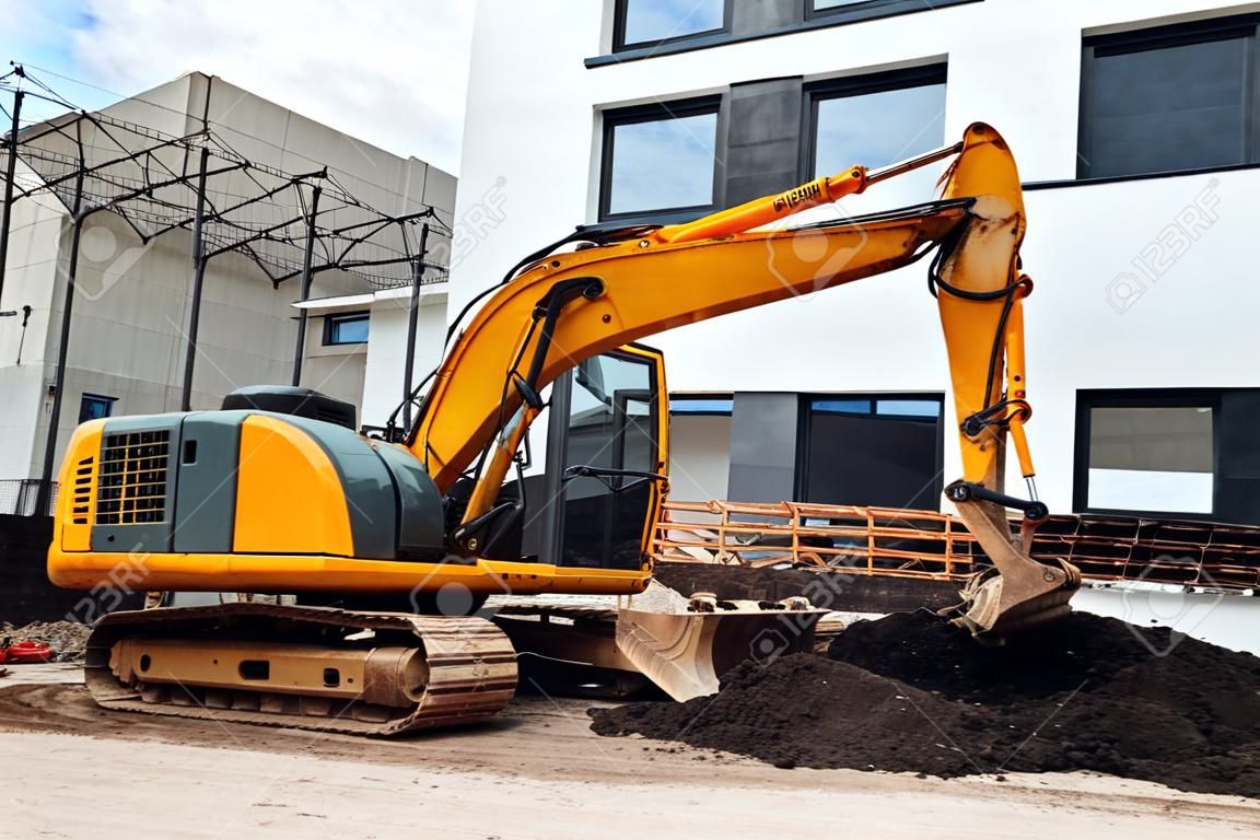 Mini heavy duty excavator moving earth for foundation building. Industrial machinery on construction site,