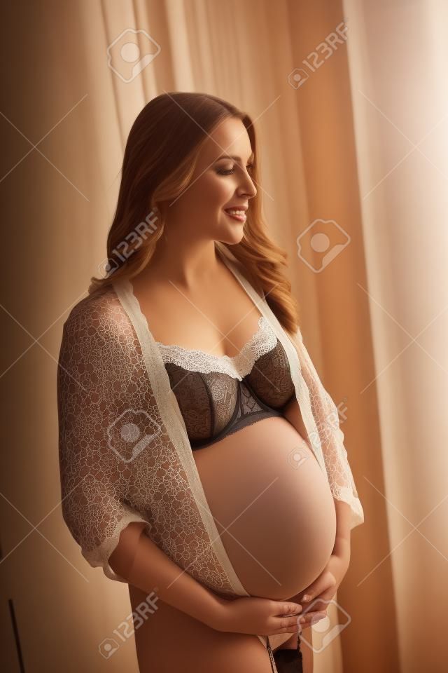 Foto van mooie zwangere vrouw dragen lingerie en poseren in de kamer